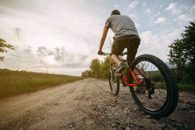 Genç adam binicilik bisiklet bir ülke Road