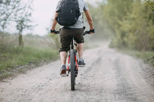 Mann mit Helm fährt mit Fahrrad auf Landstraße — Stockfoto