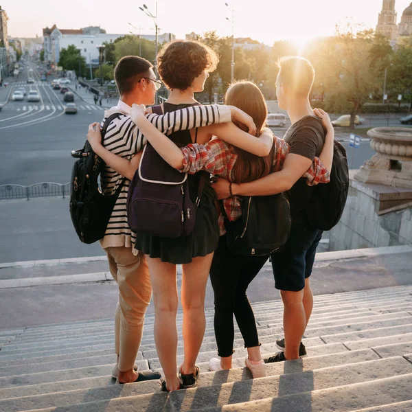 Jovens felizes abraçando olhando para a vista da cidade — Fotografia de Stock
