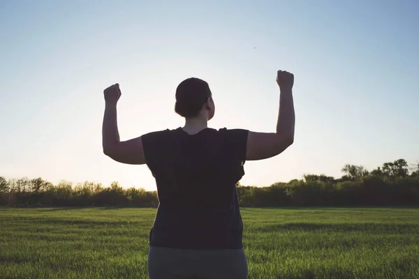 Femme en surpoids célébrant lever les mains vers le ciel — Photo