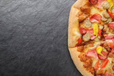 Jambonlu pizza ve arka planda küçük sosisler.