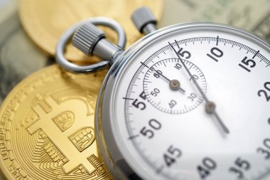 Fiziksel altın bitcoin sikkeler ve mekanik analog kronometre.