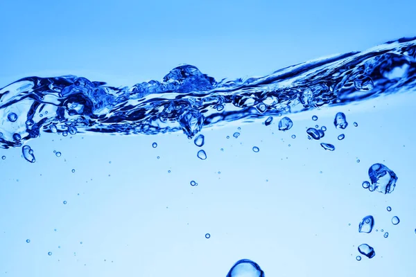 Luftblasen unter blauem Wasser und Wellen oder Spritzen — Stockfoto