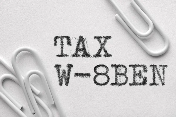 Clips de papel de plástico blanco con palabras Tax W-8BEN — Foto de Stock