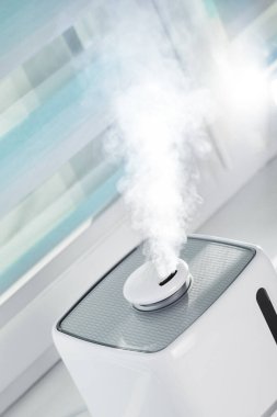 Penceredeki beyaz ultrasonik nemlendirici kuru havayı nemlendirir.