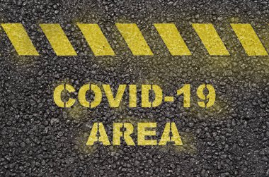 Siyah asfalt yol yüzeyinde Covid-19 alan metin uyarısı