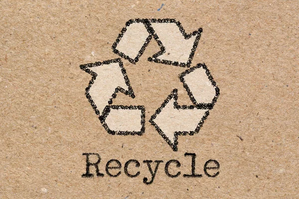 Recycling symbol on brown craft paper texture or background. Top view.