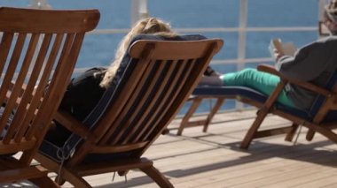 Deniz seyahat ve yolcu gemisi rahatlayın. İnsanlar şezlonglar transatlantik Cruise sırasında üzerinde rahatlatıcı. Ağır çekim görüntüleri