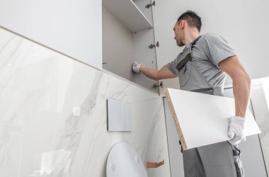 30 'lu yaşlardaki beyaz adamların yeni banyo mobilyaları. İşçi Birliği Dolapları. Ev İçleri.