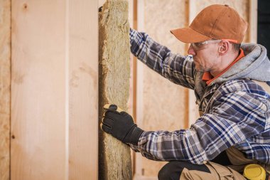 Mineral Yün İzolasyon Katmanı. İnşaat İşçisi İnşaat Evi Duvarı Yalıtkan ile Doldurma Alanı. Endüstriyel Termal Malzeme.