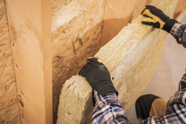 合成鉱物繊維壁断熱仕事 建設労働者熱材料で家の壁を断熱 — ストック写真