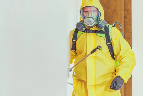 杀毒消毒 防毒衣和护肤面罩工人使用化学剂向室内喷洒防毒面罩以防止病毒传播 — 图库照片