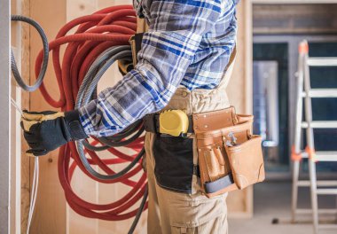 Beyaz İşçi Elektrik Kabloları ile Ev İçinde Yerleşik Elektrik Hatları Kuruyor.