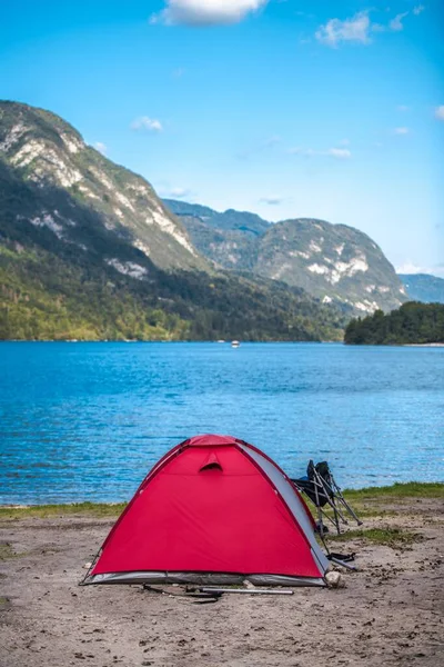 Tent Camping. Modern Tent on the Lake Waterfront. Scenic Slovenian Landscape with Mountains. Vertical Photo