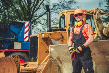 Ağır Görev Makineleri ve Güvenlik Ekipmanlı İşçi İnşaat Alanı.