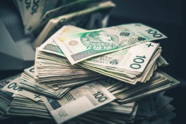 Masaya yığınla Polonya Zloti Nakit Parası. Banknotlar Arkaplanda Sayım Makinesi. Mali Endüstri.