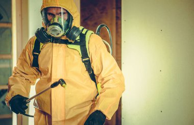 Tehlikeli Madde Giysisi ve Tam Yüzlü Maske Giyen İşçi İçindeki Bakteri ve Virüsleri Öldürmek İçin Sıvı Dezenfekte Etme.