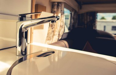 Modern RV Dinlenme Aracı Seyahat Karavanı Mutfak Alanında Lavabo. Yol Temasında Yemek Pişirme.