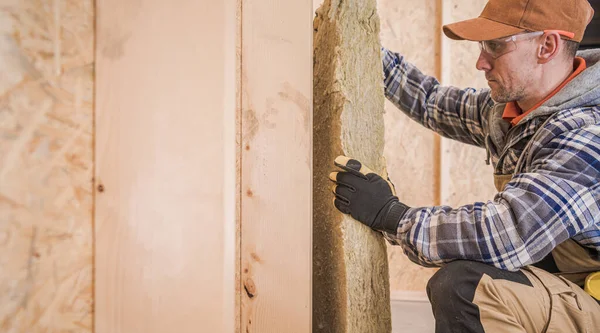 白人建設請負業者労働者工業用ミネラルウールのピースで家の壁を断熱 — ストック写真