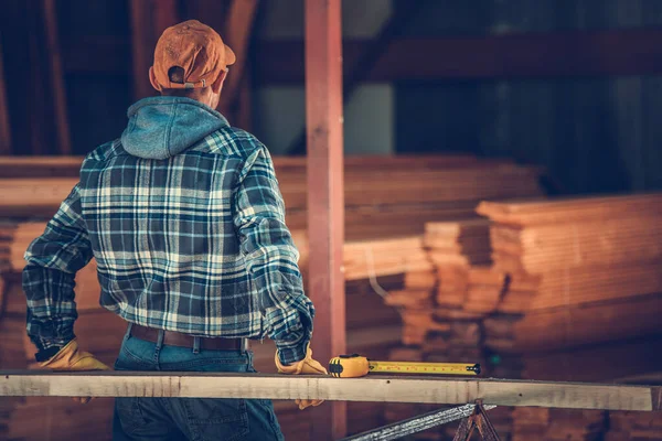 Mittdreißiger Schreiner Überprüft Bauholz Das Für Den Job Benötigt Wird — Stockfoto