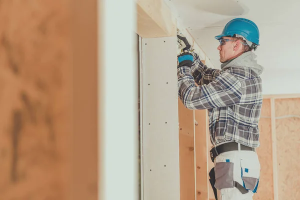 新しい家の建設に木製のフレーミングを介して男性電気事業者の給電線 — ストック写真