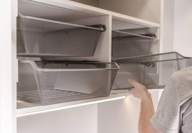 Beyaz Tamirci Dolap Alanında Yürüyen Gümüş Metal Sepetleri Toplar ve Ayarlar. 