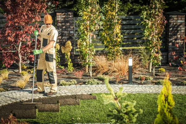 白人男性庭師は 新しい芝をインストールするには 砂のロールを敷設する準備土壌をランク付け — ストック写真