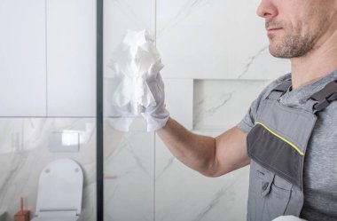 Kafkas Erkek Temizlik Ekibi Üyesi Kağıt Havlularla Duş Cam Kabini Temizliyor. 