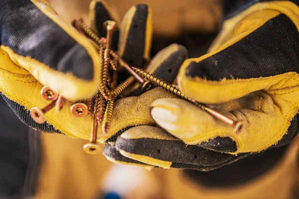 Close Construction Worker Hands Gloves Holding Bunch Golden Long Screws — Stock Photo, Image