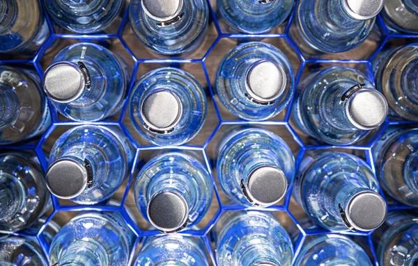 Multiple Glass Water Bottles Pop Tops Organized Blue Wire Holders — Stock Photo, Image