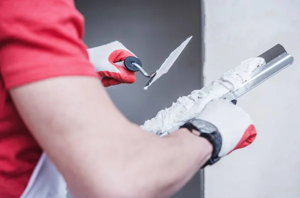 プロのタッピングナイフを使用してドライウォールコンパウンドの薄いコートを適用する建設男性労働者の閉鎖 — ストック写真