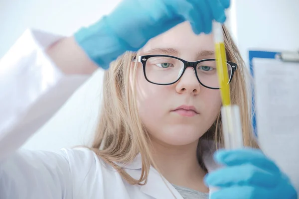 化学班的学龄女孩使用试管和带保护眼镜的皮埃特实验服和手套 — 图库照片