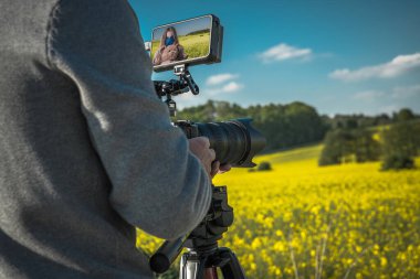 Dijital Kamerayla Açık Hava Film Yapımı. Arka planda Manzaralı Renkli Manzaralı Kafkasyalı Kız Fotoğrafları Çekiyor. Yüksek Çözünürlüklü Dış Video Kaydedicisiyle Modern Dijital SLR Kamerası.