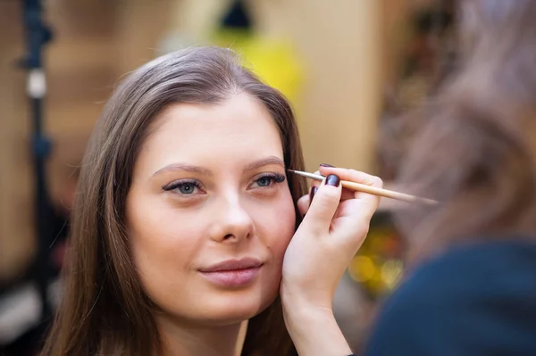 Maquillaje artista hace hermosa niña cambio de imagen —  Fotos de Stock