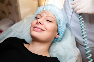 Face Beauty Treatment. Woman Getting Facial Darsonval Therapy Using High Frequency D'Arsonval, Skin Care Device For Anti Spot An clipart