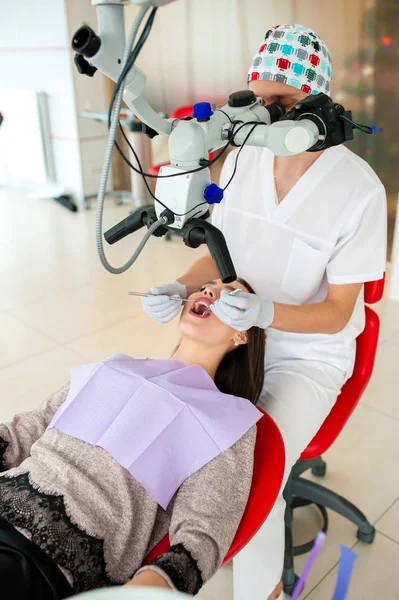 Dentysta jest decydując się na piękną dziewczynę w stomatologii — Zdjęcie stockowe