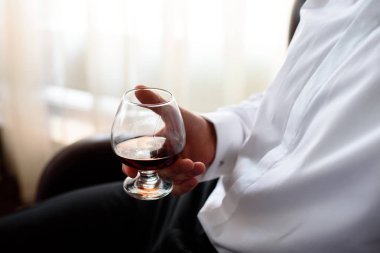 Bir bardak konyak erkekler el tutar.