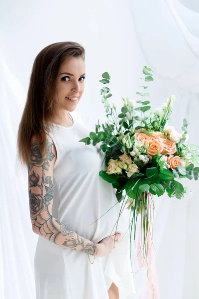 Menina grávida bonita com tatuagem e flores — Fotografia de Stock