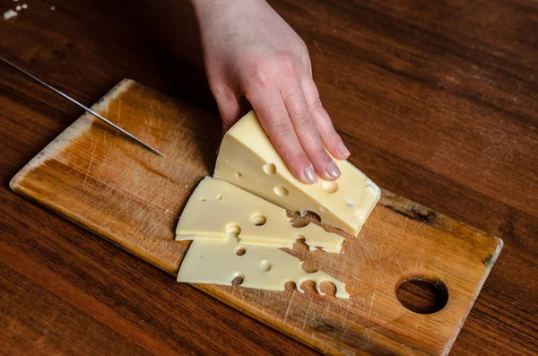 Cortar queso en una tabla de madera . — Foto de Stock