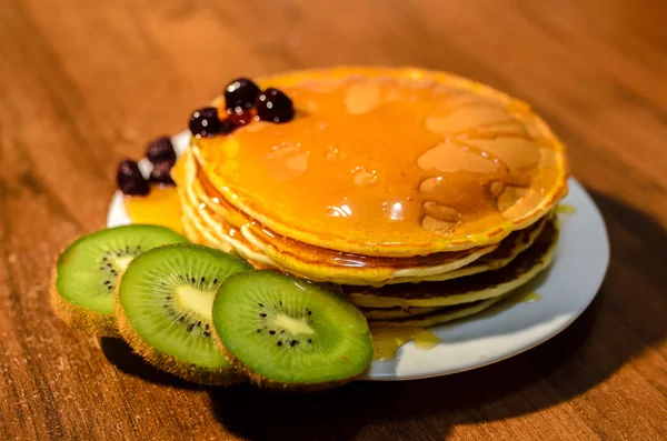 Leckere Pfannkuchen mit Honig, Kiwi und Beeren. — Stockfoto