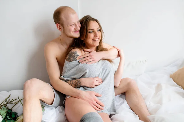 Schönes Paar in Erwartung eines Kindes, im Bett liegend. — Stockfoto