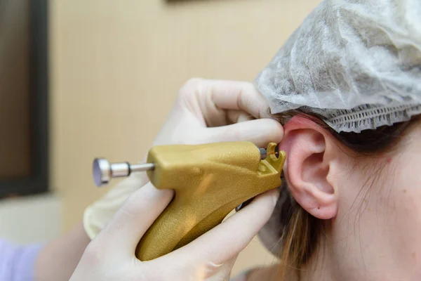 Ears piercing the girl