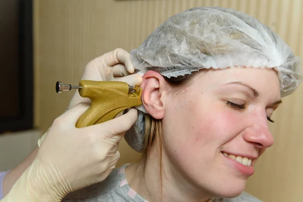 Ears piercing the girl