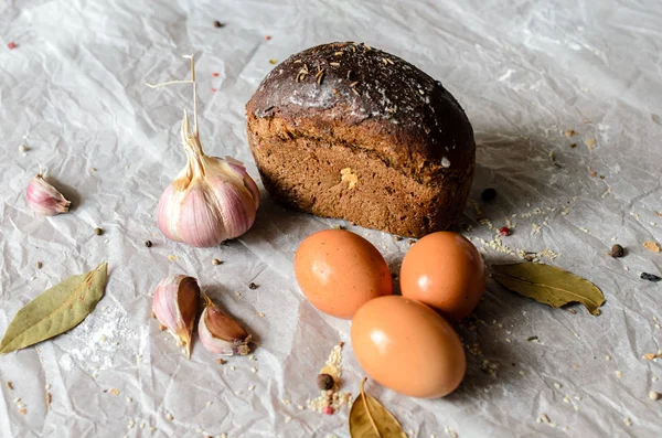 Csendélet, kenyér, tojás, fokhagyma és fűszerek. — Stock Fotó