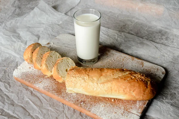 Natura morta di un bicchiere di latte e pane a fette . — Foto Stock