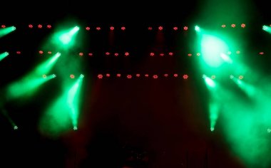 Sahne ışığı, renkli ışıklar ve dumanla.