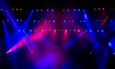 Sahne ışığı, renkli ışıklar ve dumanla.