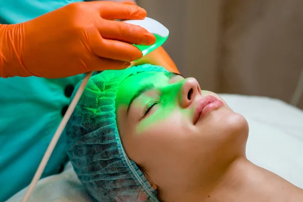Mujer joven recibiendo tratamiento láser de epilepsia en la cara en el centro de belleza .. —  Fotos de Stock