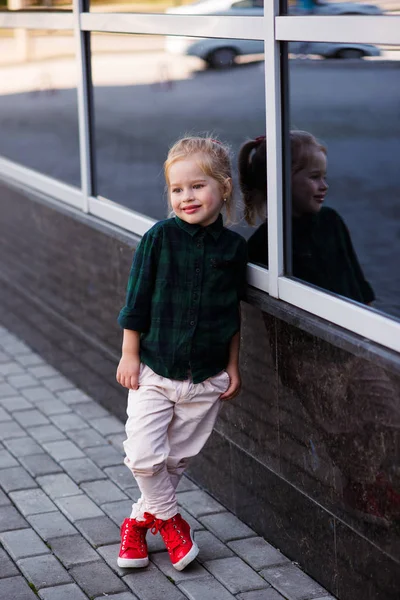 Aranyos tizenéves lány 8-9 éves divatos csípő ruhában pózol fehér tégla falon — Stock Fotó