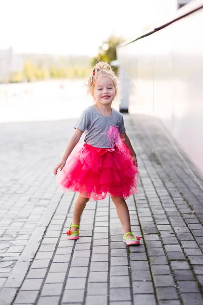 Fiatal lány, elegáns rózsaszín szoknya, lépcsőn járás — Stock Fotó
